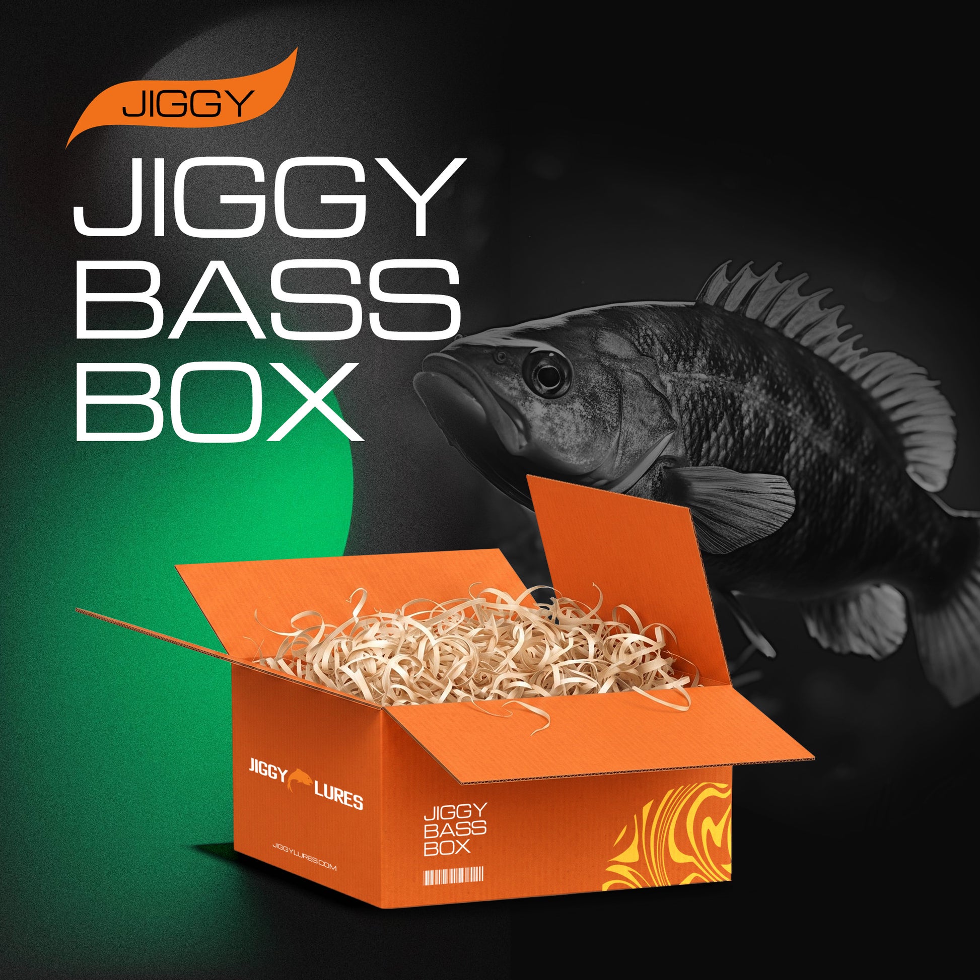 An orange JIGGY Lures 'JIGGY BASS BOX' package filled with shredded paper, shown against a dark background with a large black-and-white bass fish graphic and bold product text.